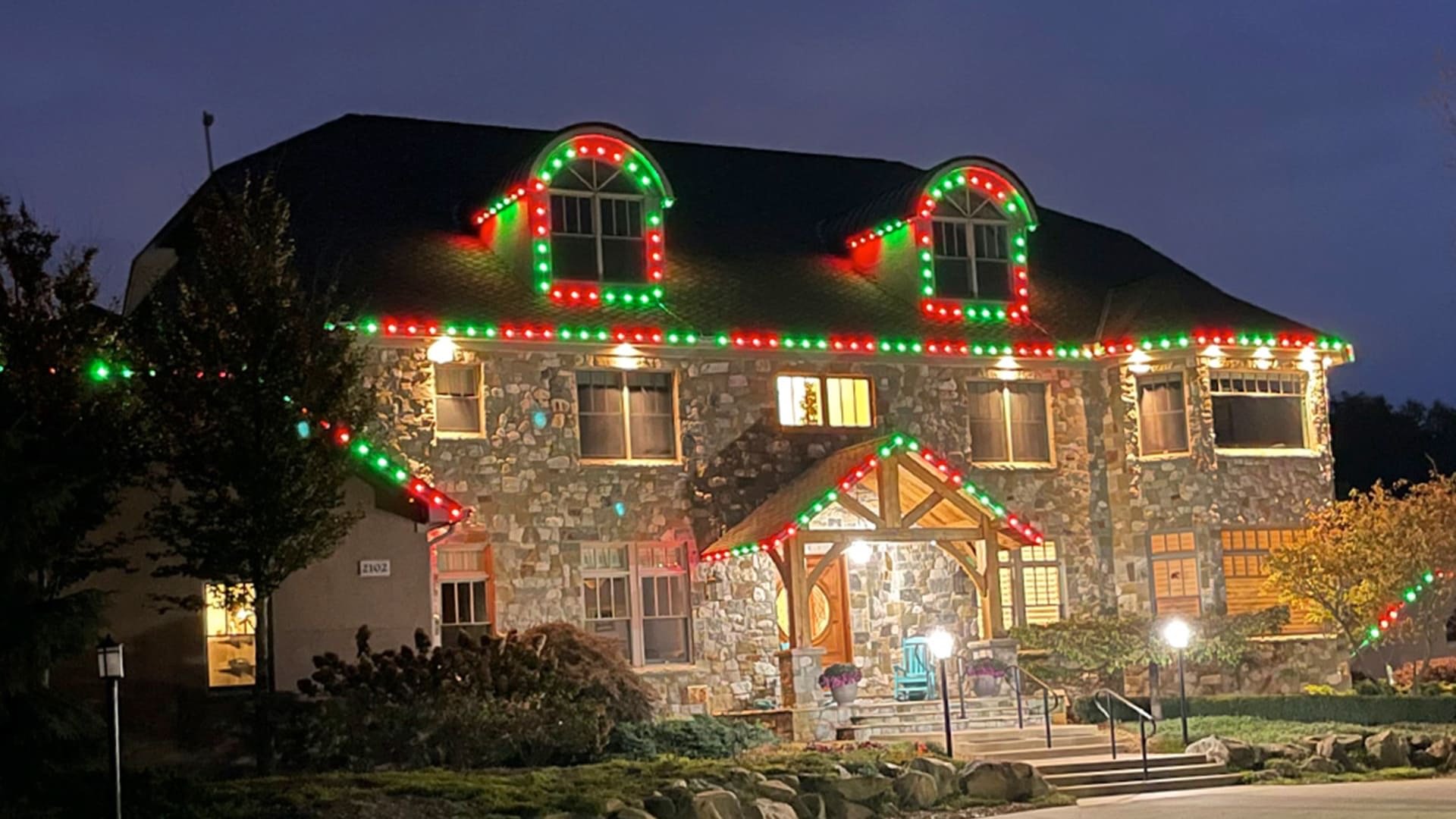 Permanent roofline lighting in red and green for Christmas