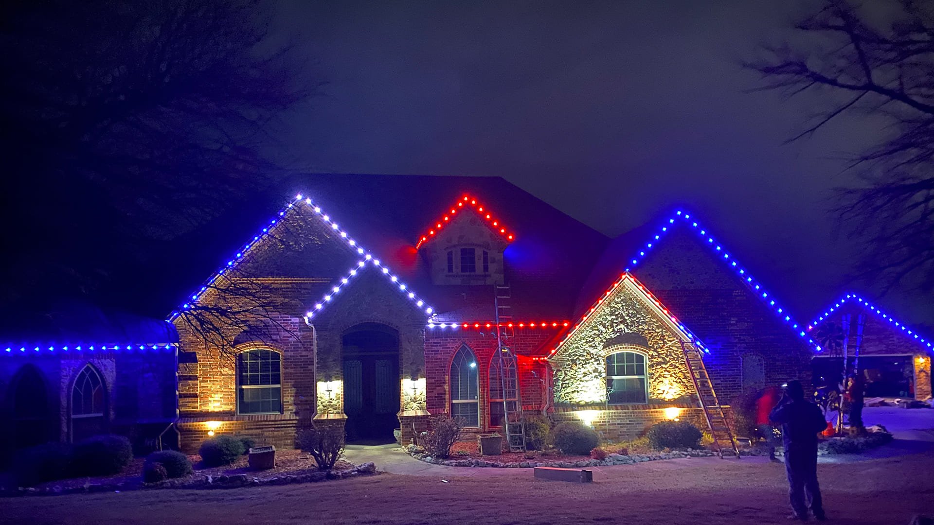 Red white and blue permanent roofline lighting on a home