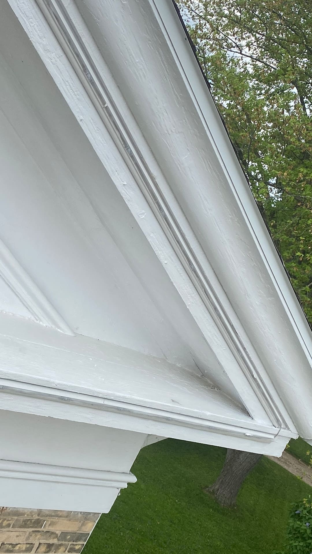 Close-up of low-profile permanent lighting track installed along white exterior trim. Close-up of low-profile permanent lighting track installed along white exterior trim.