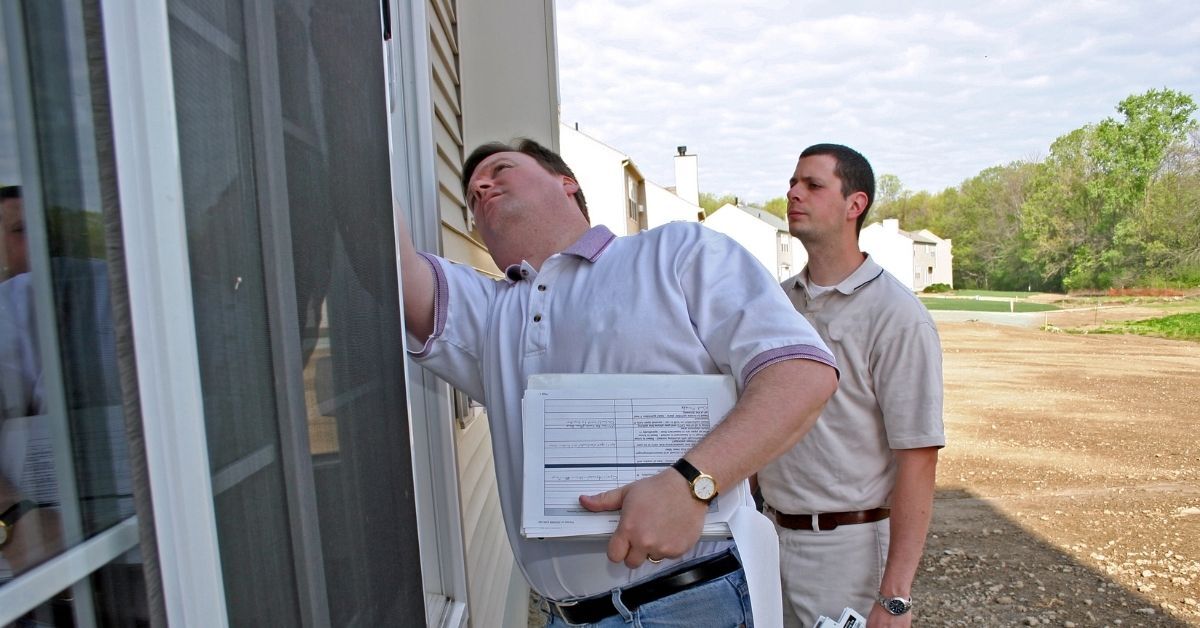 Property professionals inspecting windows at a multifamily building